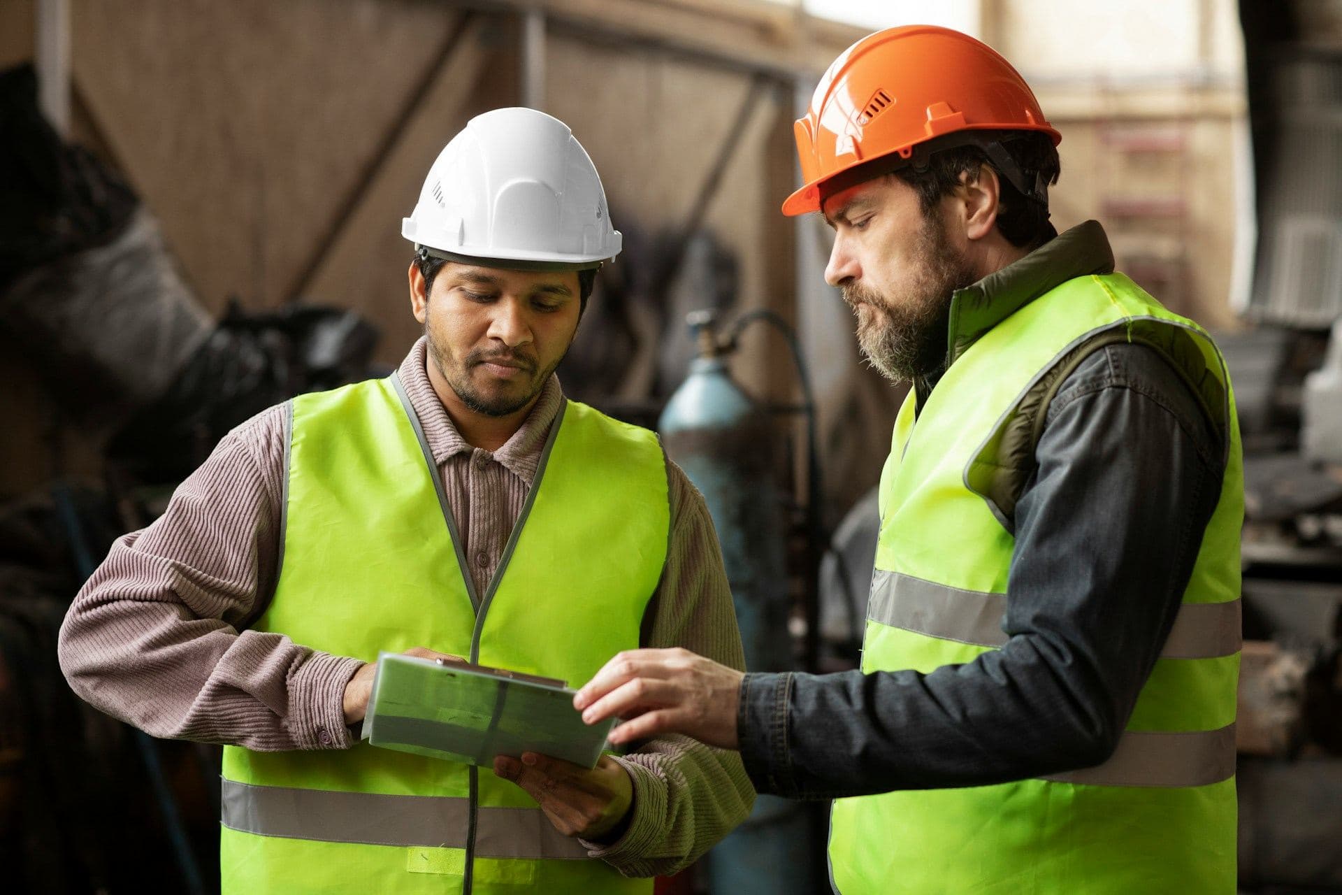 Two professionals review a plan on the shop floor